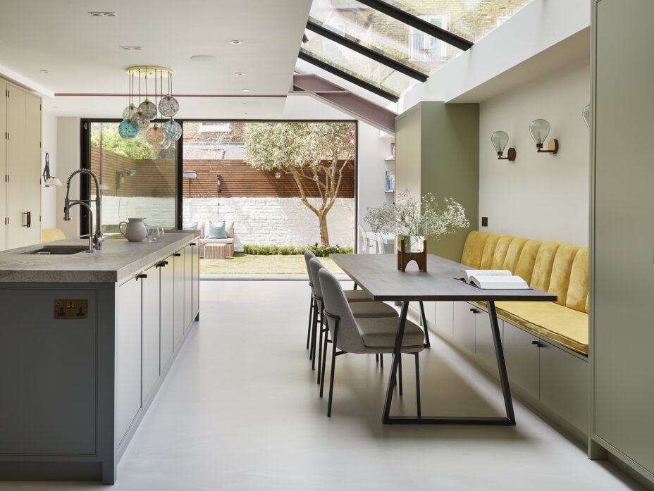 Exterior view of a modern London home with large glass doors opening to a landscaped garden.