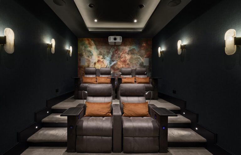 Home theatre room with dark-toned walls, integrated surround sound, and a large projection screen designed for immersive viewing.
